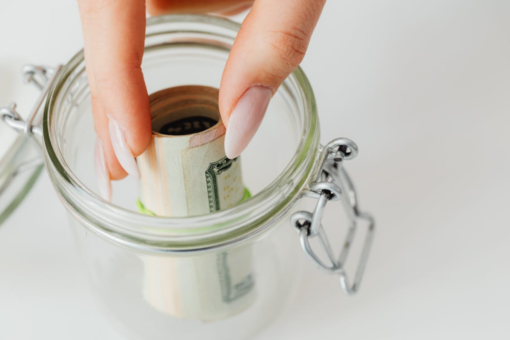 Emergency fund as a mental health tool shown by saving cash into jar.