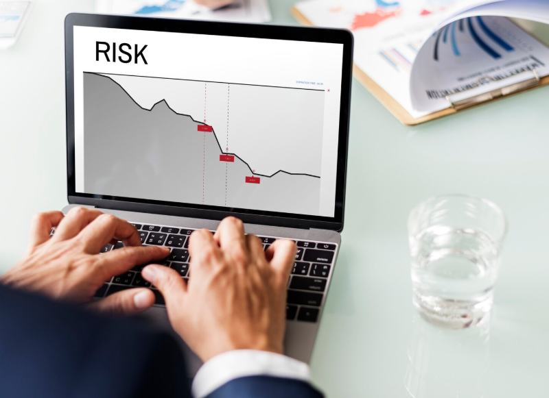 AI financial risk prediction displayed through a declining risk trend on a laptop